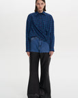 A person modeling a blue checkered shirt and black trousers. PRIME SHIRT BLUE 